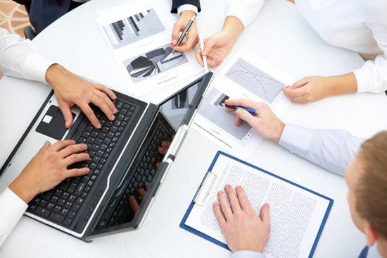 Image of business people hands working with papers and typing at meeting